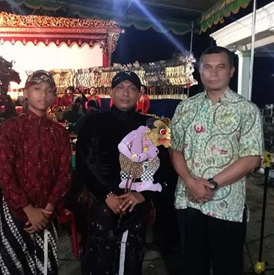 Ki Bambang Wiji Nugroho menerima wayang Bagong dari Kepala Dinas Kebudayaan Bantul diapit oleh dalang cilik Raka Wresniwira Purnama Aji. foto Ki Agus